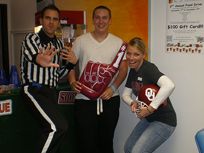 Three people in casual attire pose together indoors at an Emerson Orthodontics event or office setting.