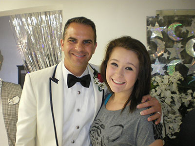 Man in tuxedo and woman smiling together indoors at formal event