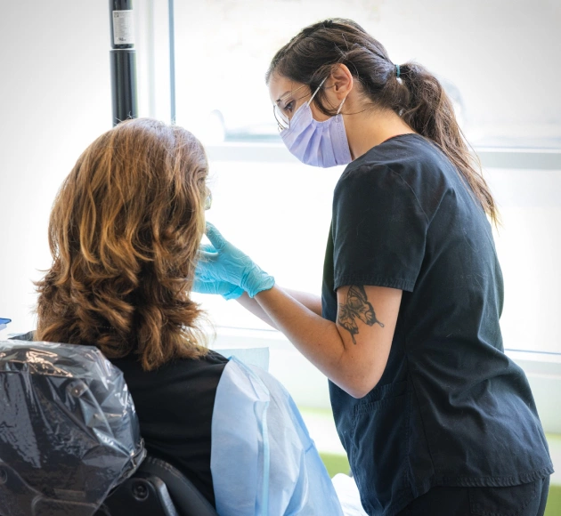 Orthodontist examining patient's teeth during dental consultation in clinical office setting.