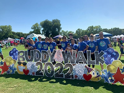 Orthodontics team members pose together at outdoor community event with "Emerson 2022" banner.