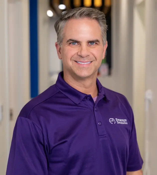 Dr. Clinton Emerson, dentist at Broken Arrow dental practice, wearing purple polo shirt.